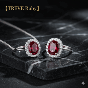 「【TREVE Ruby】」のロゴが左上に配された、重厚な黒大理石のステージ。中央には、深く鮮やかな赤色のオーバルカット・ルビーを主役に、周囲を煌びやかなメレダイヤモンドで豪華に取り巻いたプラチナベースのリングが2点並んでいる。背景には繊細なシルバーチェーンが流れ、高松市の宝石買取専門店「TREVE」による、カラーストーンの色彩と輝きを正当に評価する査定イメージ。