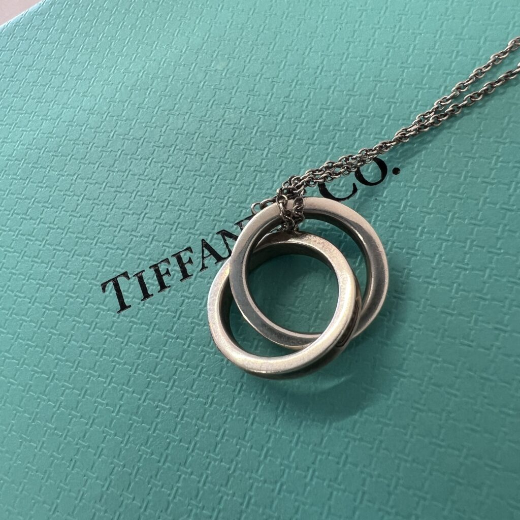 高松市のトレリバで買取したティファニー（Tiffany & Co.）の1837 インターロッキング サークル（ダブルリング）ネックレスと外箱の画像。