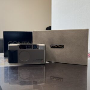 高松市のトレリバで買取したCONTAX T2 フィルムカメラと高級感のある純正ケース・ストラップの画像。