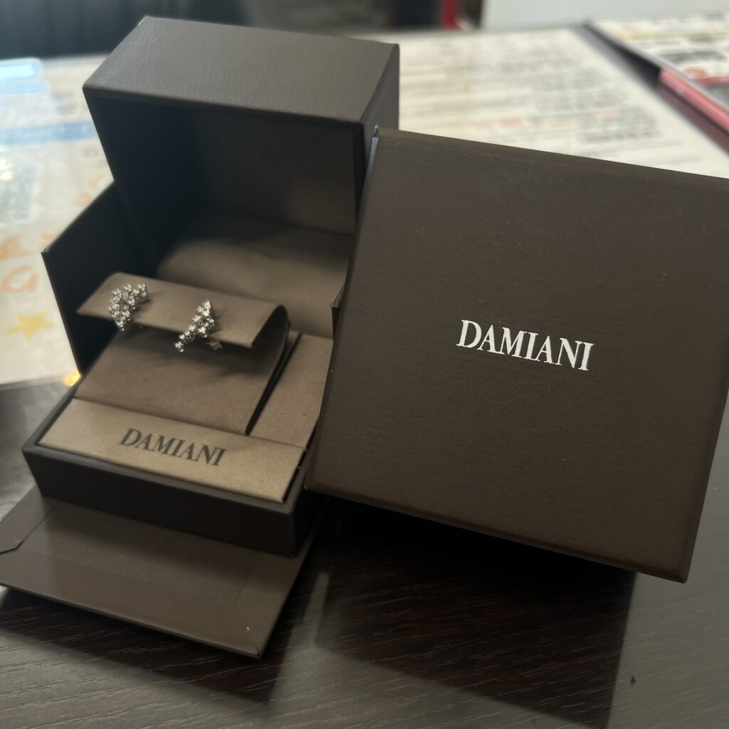 高松市のトレリバで買取したダミアーニのミモザダイヤモンドピアス750WG。専用ケースと外箱が並べられた状態の接写。
