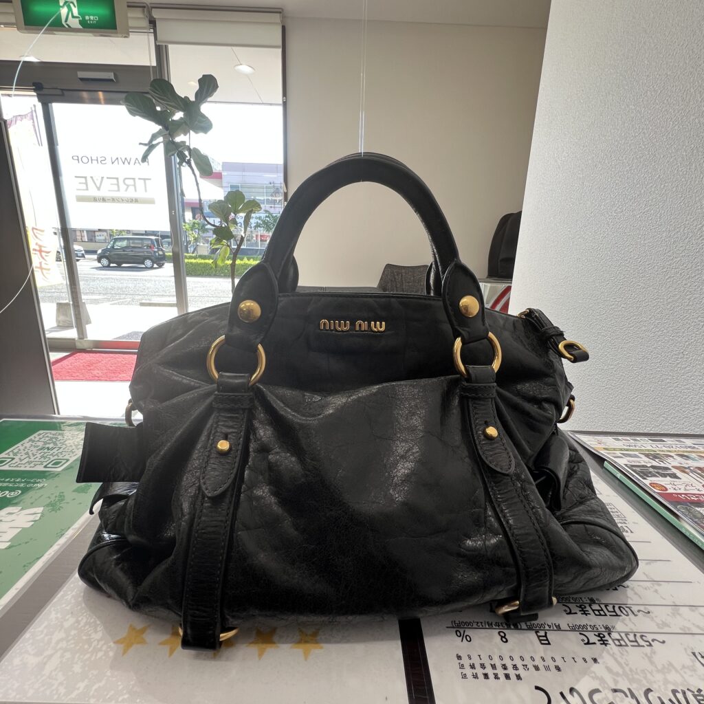 高松市のトレリバで買取したミュウミュウのハンドバッグ「ヴィッテロリュクス（ブラック）」。ゴールドロゴの接写。