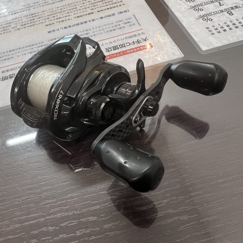 高松市のトレリバで買取したアブガルシアのベイトリール「ロキサーニ7」。ラインが巻かれた状態の黒い中古リールの画像。