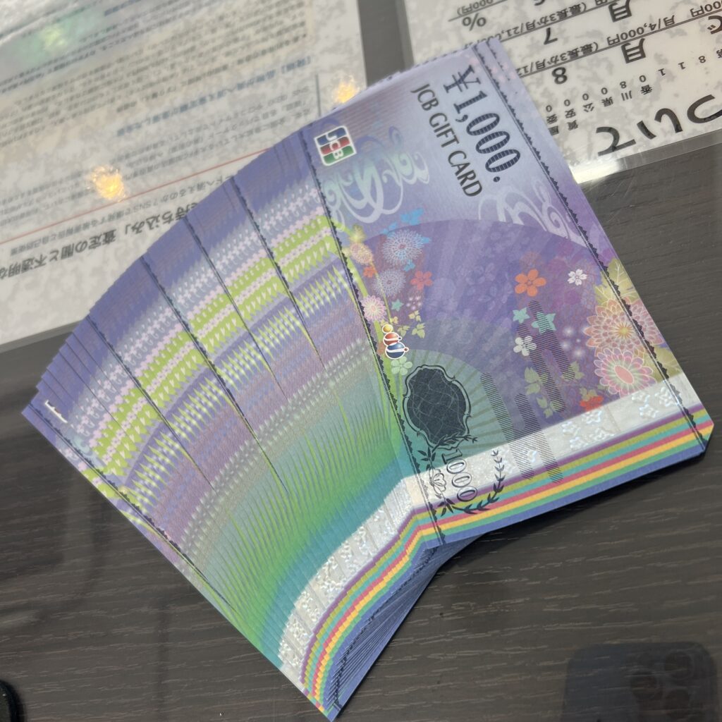 高松市のトレリバで買取したJCBギフトカード1000円券。扇型のイラストが描かれた美しい紫色の金券が重なり合った画像。
