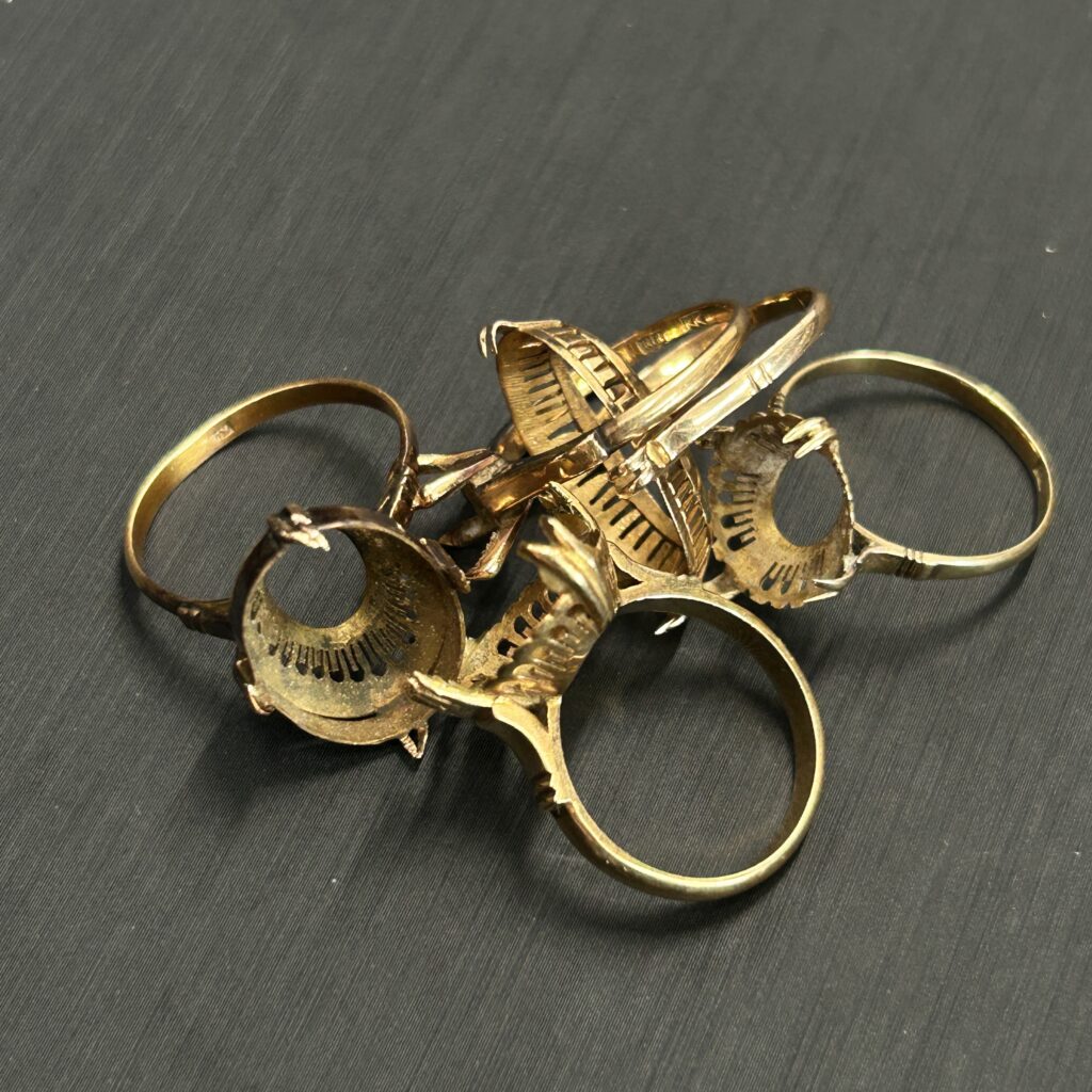 高松市のトレリバで買取したK18リング枠。宝石が外れた古い18金指輪枠が重なり合った画像。