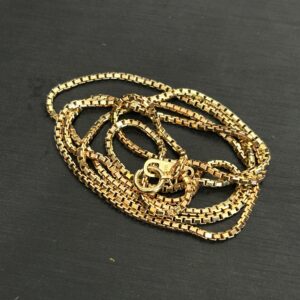 高松市のトレリバで買取したK18ベネチアンネックレス。黒い背景の上に重ねられた18金ゴールド貴金属チェーンの画像。
