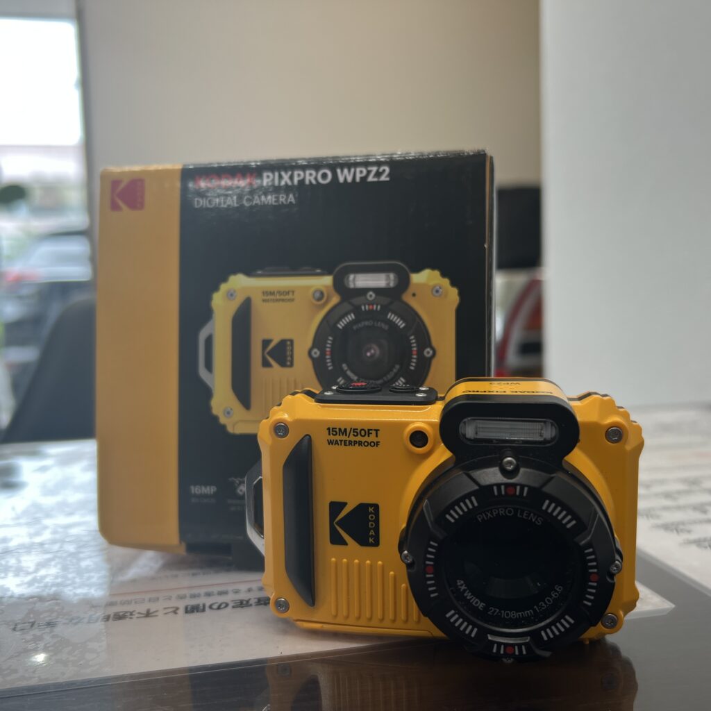 高松市のトレリバで買取したKODAK（コダック）の防水デジタルカメラ「PIXPRO WPZ2」。テーブルの上に置かれた黄色いカメラ本体と、後ろにある純正化粧箱の画像。