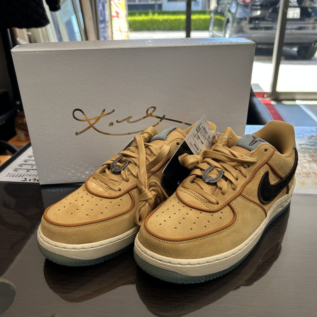 高松市のトレリバで買取したナイキ（NIKE）の限定スニーカー「エアフォース1 LOW」。テーブルの上に置かれたキャメルカラーの靴本体と、後ろにある特別仕様の白い化粧箱の画像。