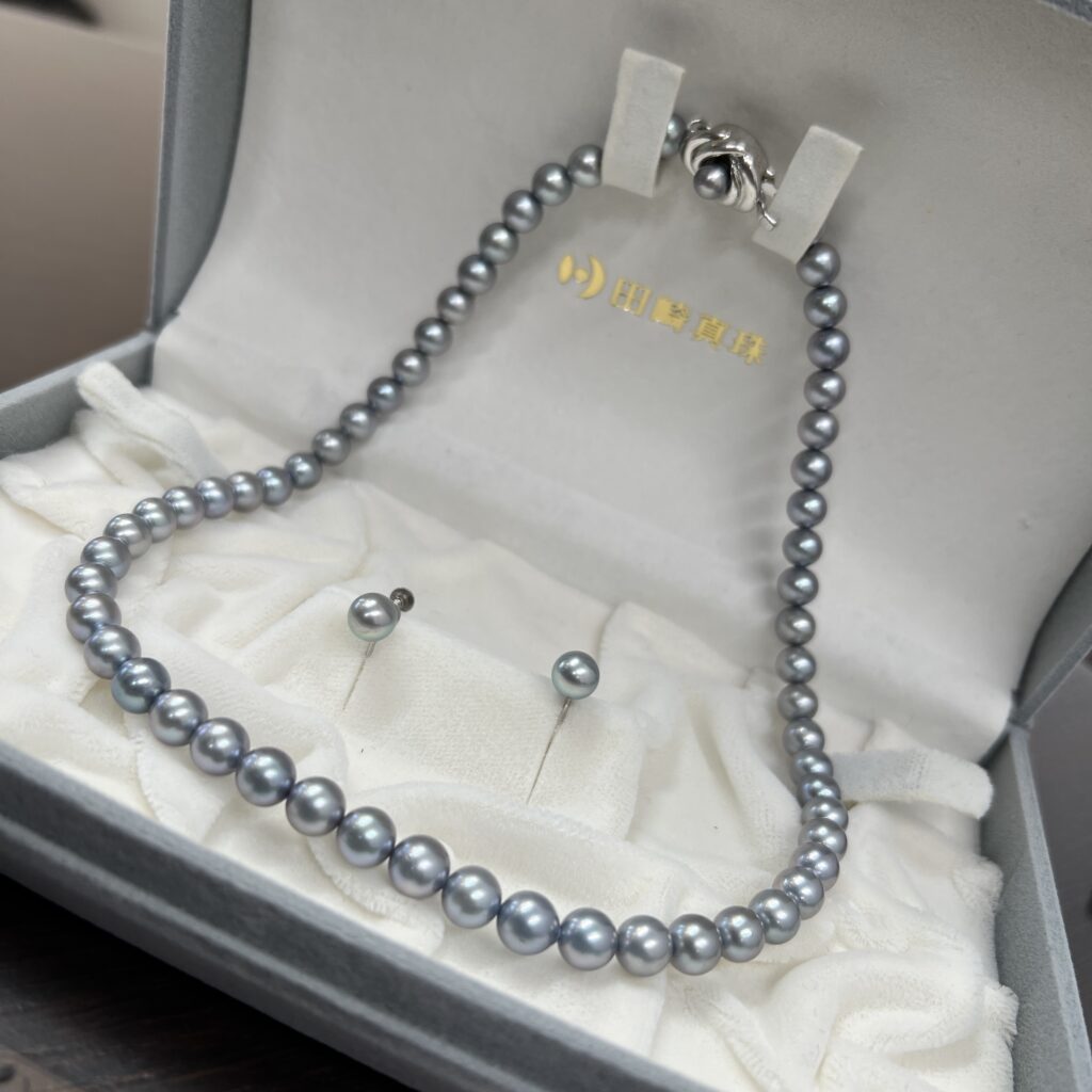 高松市のトレリバで買取したタサキ（TASAKI）のグレーパールネックレスセット。グレーのジュエリーボックスの中に収められた本真珠の画像。