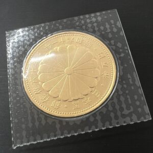 高松市のトレリバで買取した天皇陛下御在位六十年記念10万円金貨。ブリスターパックに収められた純金K24コインの画像。