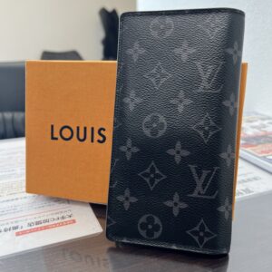 高松市のトレリバで買取したルイヴィトンの長財布「ポルトフォイユ・ブラザ」。モノグラムエクリプスの本体とオレンジの純正箱の画像。