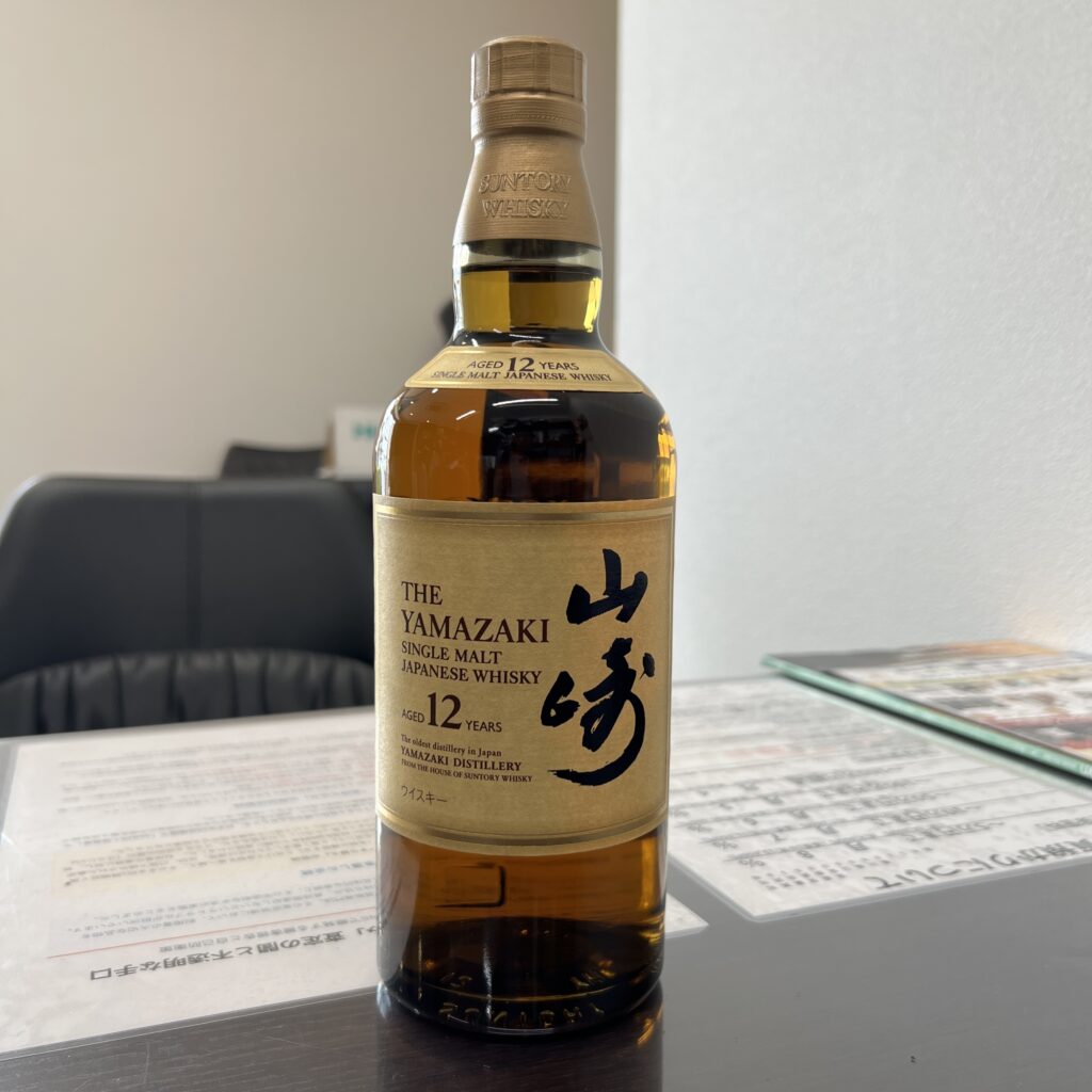 高松市のトレリバで買取したサントリーウイスキー山崎12年。テーブルの上に置かれた、未開封のウイスキーボトルの画像。