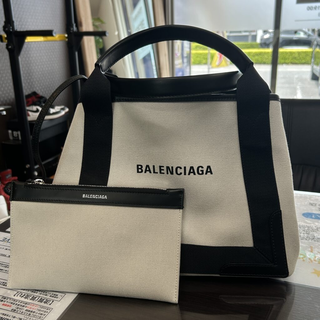 高松市のトレリバで買取したバレンシアガ（BALENCIAGA）のネイビーカバS。テーブルの上に置かれたキャンバストートバッグと前面の付属ポーチの画像。