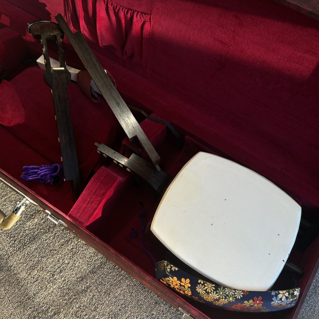 高松市のトレリバで買取した三つ折れ和楽器三味線。赤いベロア内装のハードケースの中に綺麗に並べられた高級棹と胴の画像。