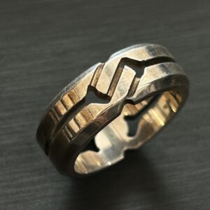 高松市のトレリバで買取したグッチのインフィニティリング。黒い背景の上に置かれたAg925シルバーリングの画像。
