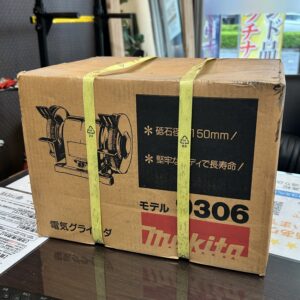 高松市のトレリバで買取したマキタの電気グラインダ(9306)。黄色いバンドが掛けられた茶色い段ボール外箱パッケージの画像。