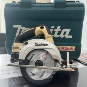 高松市のトレリバで買取したマキタの125mm充電式マルノコ限定仕様。ゴールドの本体と後ろにあるグリーンの純正キャリングケースの画像。
