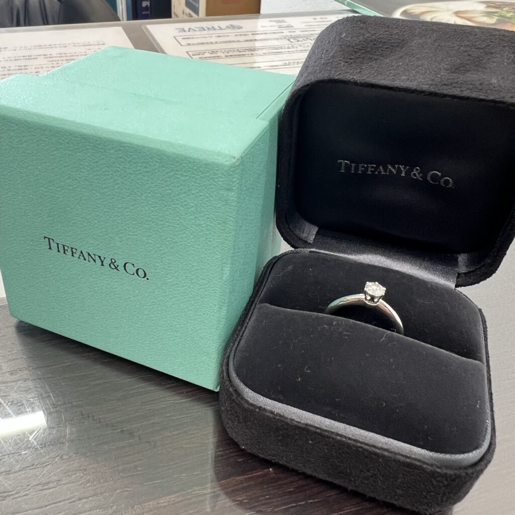 高松市のトレリバで買取したティファニーのソリティアダイヤモンドリング。ティファニーブルーの外箱と黒いケース、プラチナダイヤ指輪の画像。