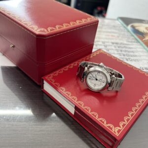 高松市のトレリバで買取したカルティエのパシャCビッグデイト。カルティエの赤いケースと冊子、ステンレス自動巻き腕時計の画像。