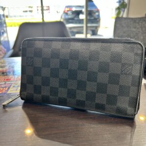 高松市のトレリバで買取したルイ・ヴィトンのオーガナイザー長財布。テーブルの上に置かれたダミエ・グラフィット柄のラウンドファスナー長財布の画像。