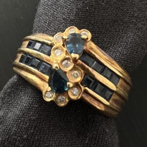 高松市のトレリバで買取したK18サファイアダイヤモンドリング。リングスタンドにセットされた豪華な金とサファイアの指輪の画像。